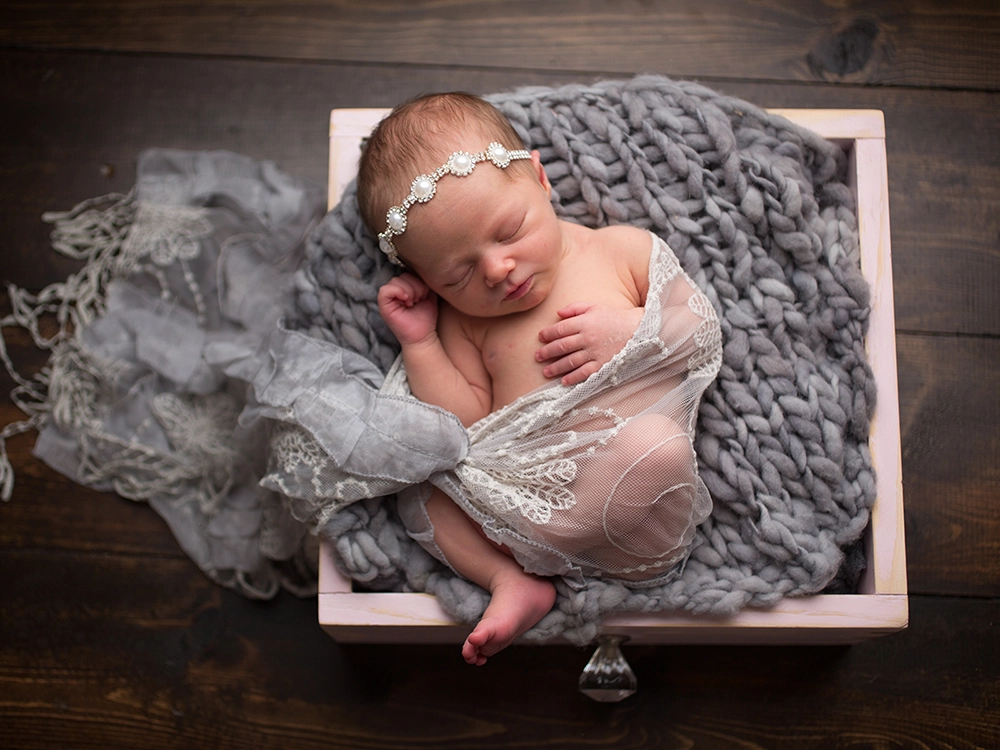 Newborn photo editing of a baby in a box with wraps.