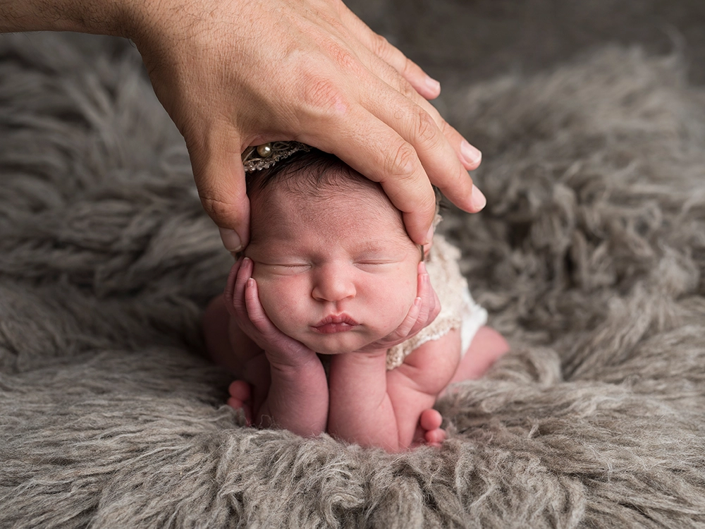 Newborn photo editing of a baby on grey fur.