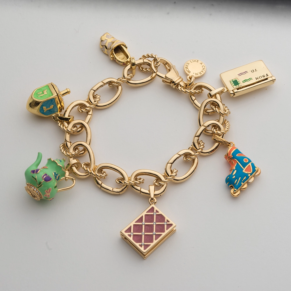 Gold charm bracelet with intricate details and clean shadow removal